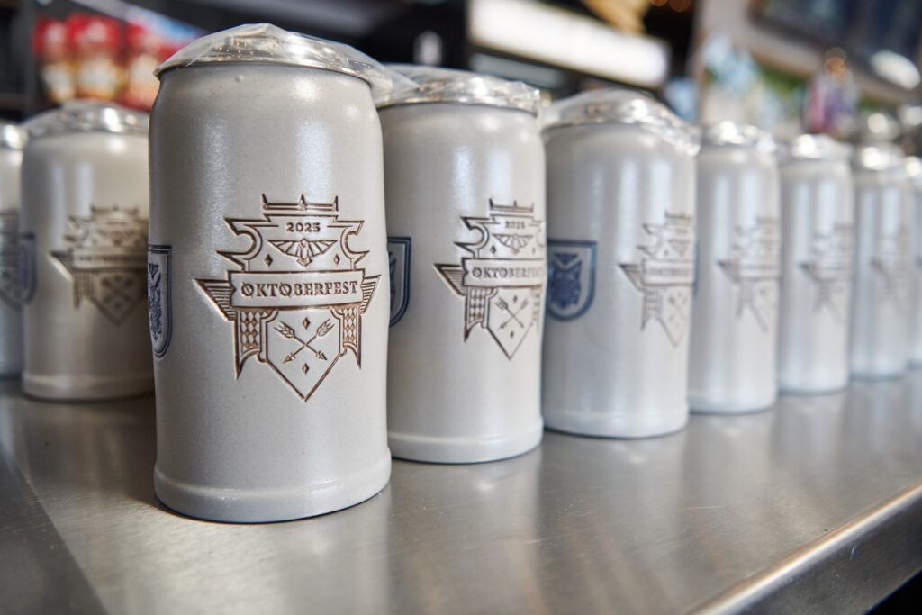 Rows of Crow and Wolf commemorative Oktoberfest steins lined up along the taproom bar